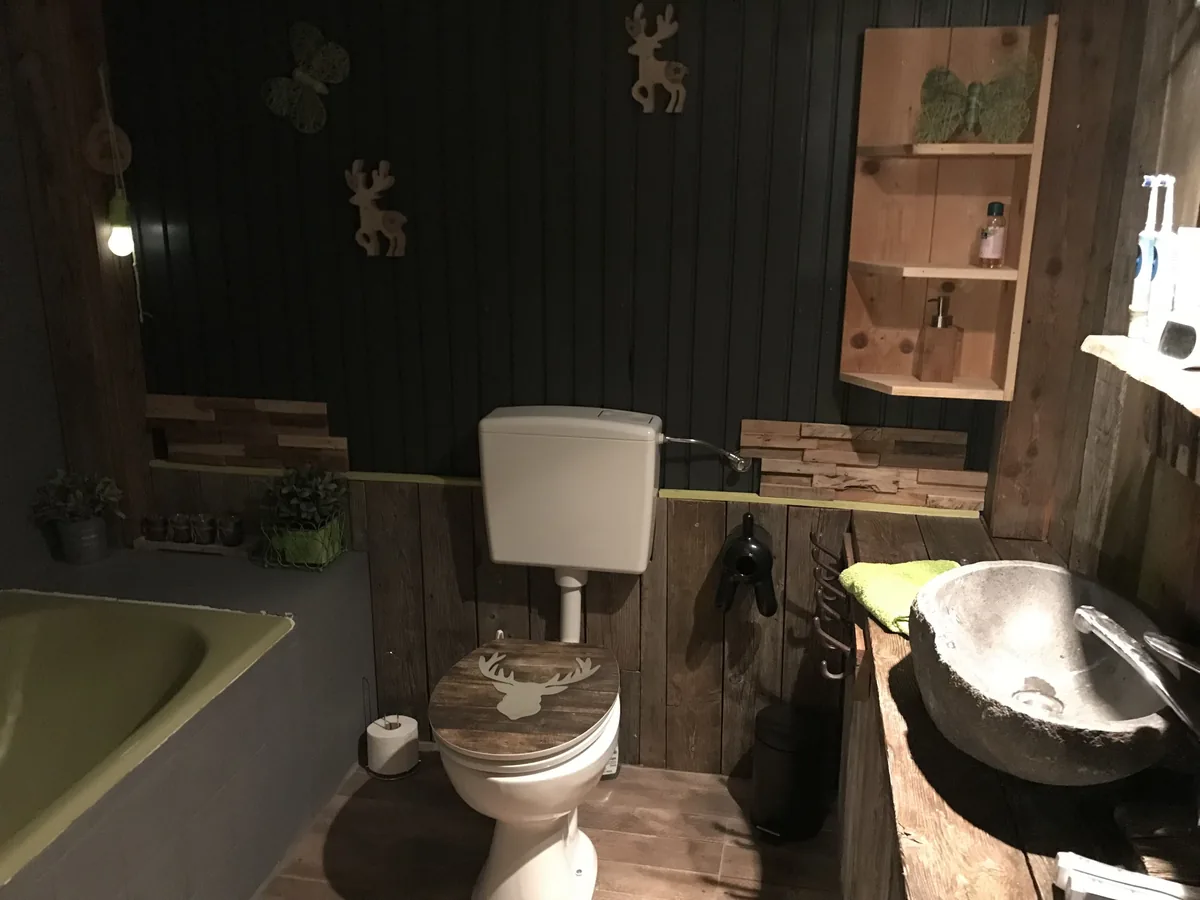 Badkamer met bad en een stenen wasbak